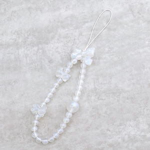 Close-up of beaded phone strap with white pearlescent finish and bow decorations