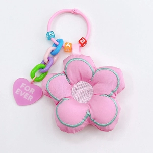 Détail d'un porte-clés fleur en tissu rose avec perles et pendentif coeur