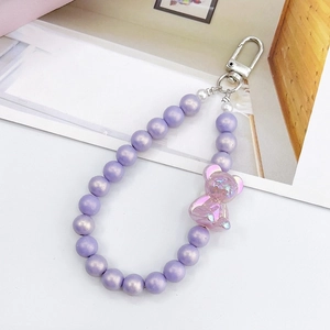 Dettaglio di perle acriliche viola e ciondolo a forma di orso con chiusura in argento