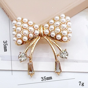 Detailed view of pearl bow shoe charm with rhinestones and tassels, 35mm size