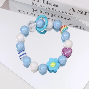 Detailed macro shot of beaded bracelet with pearl blue beads and heart-shaped pendant