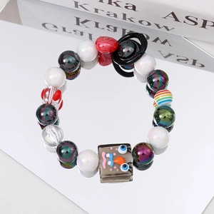 Detail of colorful beaded bracelet featuring a unique rectangular cartoon pendant with eyes
