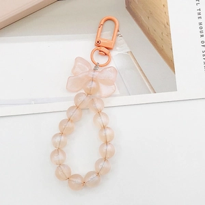 Detailed view of champagne pink beaded keychain featuring a matte ribbon bow charm