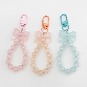 Detailed view of pink, peach, and ice blue beaded keychains with matte bows