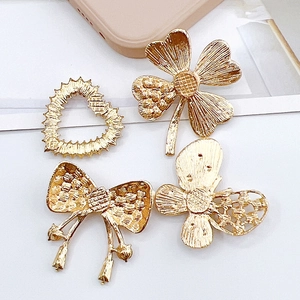 Set of 4 gold metal shoe charms with clover, heart, and pearl bow designs for DIY decor