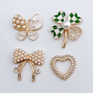 Detail view of pearl bow and checkered clover shoe charms for DIY fashion accessories