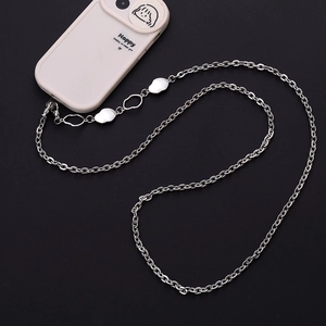 Macro shot of silver metal crossbody phone chain with irregular polished pendants and clasp