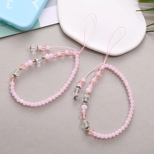 Detailed view of pink frosted crystal beads with gold floral accents on phone lanyard