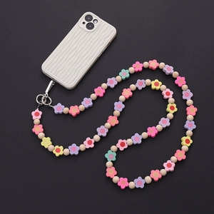 Macro shot of colorful acrylic flower beads and wooden beads on a long mobile phone strap