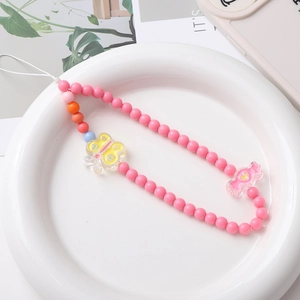 Sweet pink acrylic beaded phone wrist strap with butterfly and candy charms on white plate
