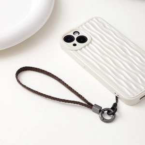 Detail of hand-woven dark brown leather phone wrist strap with metallic ring clasp