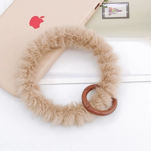 Détail de la dragonne en peluche marron clair avec fermoir rond pour coque de téléphone