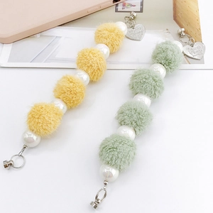 Chic plush ball and iridescent pearl phone strap accessory in yellow and mint colors