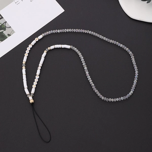 Détail d'une lanière de téléphone en cristal avec perles LOVE et accents dorés