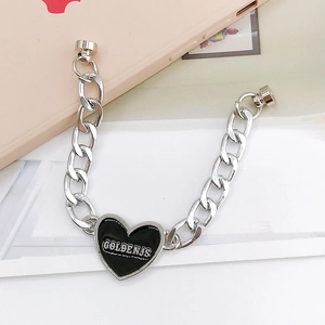 Détail de la chaîne en métal argenté avec pendentif cœur noir et fermoir magnétique