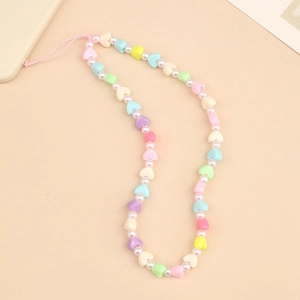 Colorful macaron heart beads and faux pearl phone strap for women on beige background