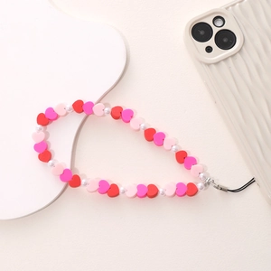 Dettaglio del laccetto per cellulare con perle a cuore in resina rossa e rosa e perle bianche
