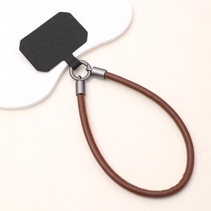 Detail of brown leather phone wrist strap with gunmetal clip and black connector pad
