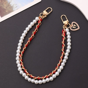 Detail of red leather woven chain with white pearls and heart bow charm pendant