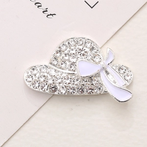 Detailed close-up of a silver sun hat charm with sparkling rhinestones and a white bow