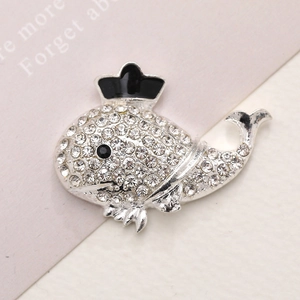 Dettaglio macro della spilla a balena in lega d'argento con strass e corona nera smaltata