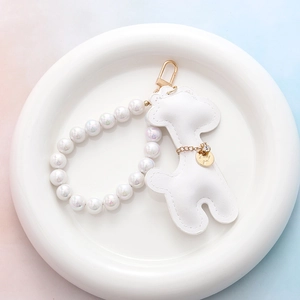 Détail du porte-clés cerf en cuir blanc avec perles nacrées et breloque dorée Lucky Girl