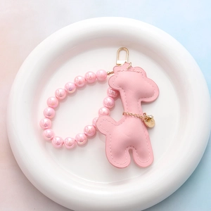 Vue détaillée d'un porte-clés girafe en similicuir rose avec bracelet de perles
