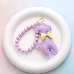 Porte-clés caniche en similicuir violet avec perles irisées et fermoir en métal doré