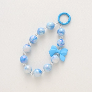 Detailed view of blue and white marble bead phone charm with light blue bow and round clasp