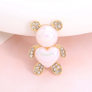 Macro shot of cute pink resin bear brooch with gold metal and sparkling crystals
