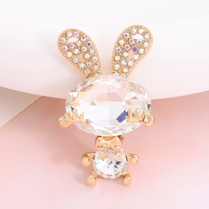 Detail of cute golden rabbit brooch with large clear gemstones and colorful rhinestones