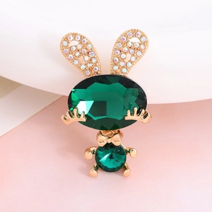 Macro view of golden rabbit charm with emerald green gemstones and sparkling rhinestones