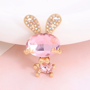 Macro shot of cute pink gemstone bunny charm with gold accents and sparkling crystals