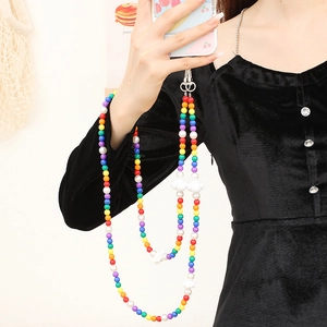 Rainbow beaded phone strap with white cloud charms and metallic clasp on a black dress