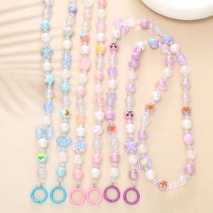 Détail de cordons de téléphone en perles colorées avec breloques étoile, ours et cœur sur beige