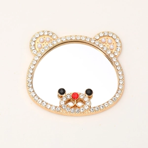 Detalle de espejo de maquillaje con forma de oso, pedrería y orejas de perla
