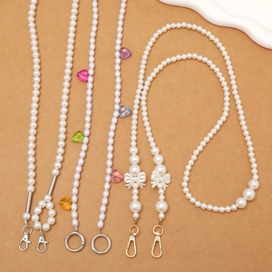 Détail de cordons en perles avec pendentifs en cœur colorés et fermoirs métalliques