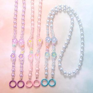 Detailed view of colorful beaded phone lanyards with floral charms in purple pink and blue