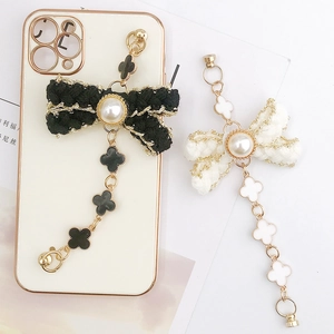 Luxe pearl bow phone case chain with clover charms and elegant tweed knit texture