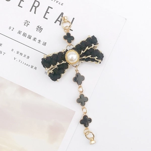 Elegant black tweed bow bracelet with pearls and clover charms on golden chains