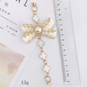 Handmade woven bowknot bracelet with pearl and clover charms in elegant white and gold