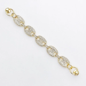 Détail d'un bracelet doré à maillons marins sertis de cristaux blancs et fermoir bijou