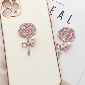 Lollipop phone case charm with pink and white rhinestones and a pearl bow accent