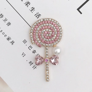 Detailed close-up of a pink rhinestone lollipop brooch with white pearl and heart crystals