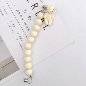 Detail of cream acrylic bear charm with matte beads and silver magnetic clasps