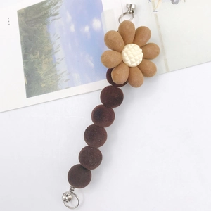 Detail of flocked flower charm with brown petals and metal clasp for DIY accessories