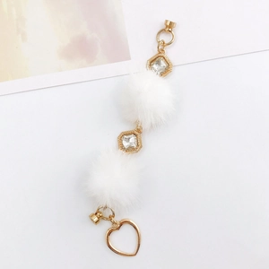 Détail de breloques en fausse fourrure avec pendentifs cœur dorés et fermoirs aimantés