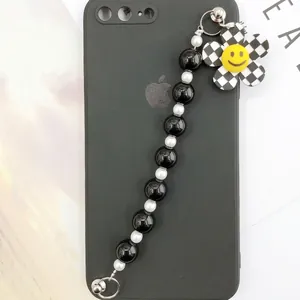 Beaded phone strap with black and white checkerboard flower charm and smiley face icon