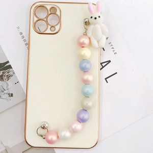 Off-white iPhone case with gold plating, colorful beads and plush bunny charm