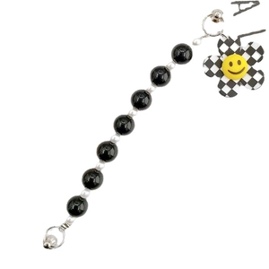 Beaded wrist strap featuring black and white beads with a smiley flower charm